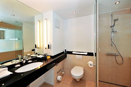 Großzügige Badezimmer mit breiten Waschtischen und Glassscheibe zum Wohnbereich