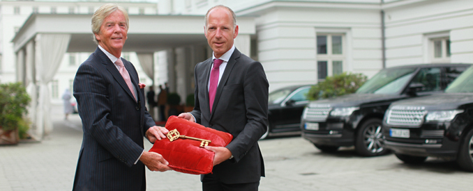 Peter J. Leitgeb (links) händigt Tim Hansen, dem neuen Hoteldirektor des Grand Hotels Heiligendamm,  symbolisch den Schlüssel für die Weiße Stadt am Meer aus (Foto: Grand Hotel Heiligendamm)